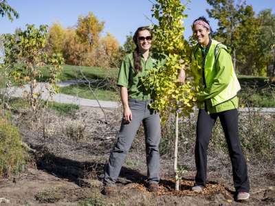 Happy volunteers with a small tree they just planted