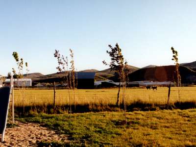 Metal slide in park with trees and hills in sunlight